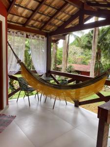 a hammock in a room with a patio at Pousada Brisa do Vale in Ipiabas