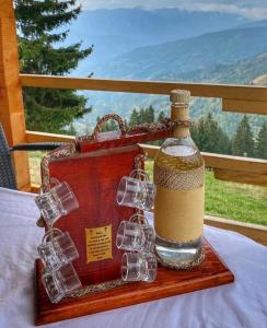 een fles wijn op een houten dienblad met glazen bij Čakorski Konaci in Berane