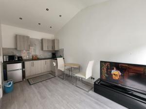 a kitchen with a large flat screen tv in a living room at Ilford Town Centre Studio in Ilford