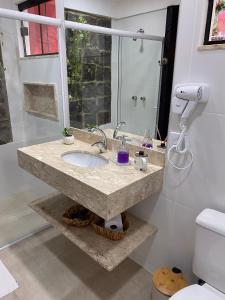 a bathroom with a marble sink and a shower at Pousada Brisa do Vale in Ipiabas