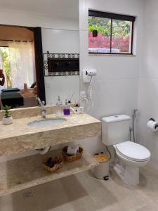 uma casa de banho com um lavatório, um WC e um espelho. em Pousada Brisa do Vale em Ipiabas