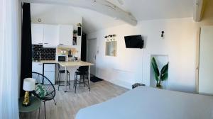 Superbe Studio jungle cœur du centre-ville في جنات: غرفة نوم بسرير ومطبخ مع طاولة