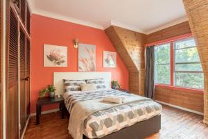 a bedroom with orange walls and a bed and a window at Private Room in Sans Souci Guesthouse in Sydney