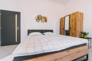 um quarto com uma cama grande e um relógio na parede em Modern living in city centre em Košice