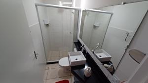 a small bathroom with two sinks and a shower at Apartamento em Pimenteiras in Teresópolis