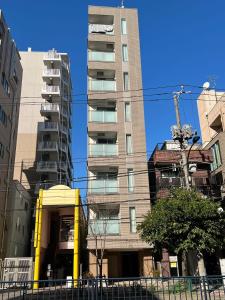 a tall apartment building in a city at SkyHotel Kikukawa 駅徒歩2分 in Tokyo