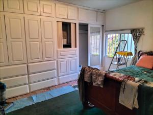 a bedroom with a bed and a wall of cabinets at Moody's Share house (rooms 4 Rent) furnished or not in Tijuana