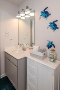 a bathroom with a sink and a mirror at Cozy Coastal Home Near Beaches, Shops, Restaurants in Southport