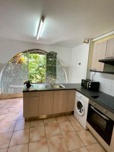 a kitchen with a sink and a washing machine at Le Toucan Tropical, F2 bis emplacement central in Fort-de-France