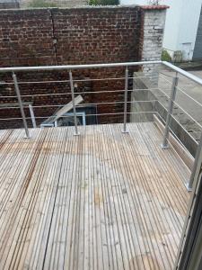a wooden deck in front of a brick wall at Appartement standing Le Havre in Le Havre