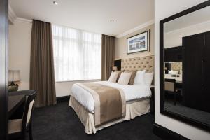 ein Hotelzimmer mit großem Bett und Schreibtisch in der Unterkunft The Vermont ApartHotel New in Newcastle upon Tyne