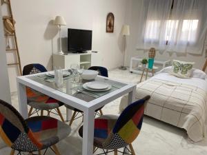 sala de estar con mesa, sillas y cama en AljaLux Sevilla Bormujos, en Bormujos
