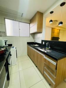 eine Küche mit einer Spüle und einer Arbeitsplatte in der Unterkunft Apto VIP em frente à ARENA MRV / Expominas in Belo Horizonte