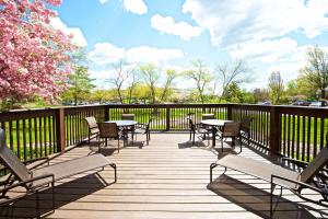 una terraza de madera con mesas y sillas y una valla en Sheraton Bucks County Langhorne, en Langhorne
