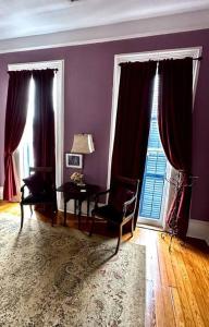 un soggiorno con pareti viola, tavolo e finestra di The Dragonfly Treme-Close to French Quarter-Heated Salt Pool a New Orleans