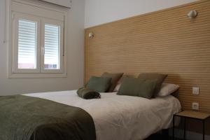 sypialnia z dużym łóżkiem z drewnianym zagłówkiem w obiekcie Bambú Suites Vegueta w mieście Las Palmas de Gran Canaria