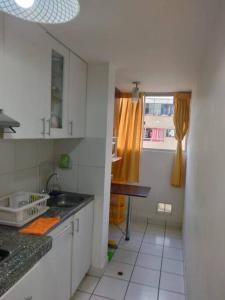 uma pequena cozinha com um lavatório e uma janela em Tait's House - Cómodo departamento Dúplex - Ate em Lima