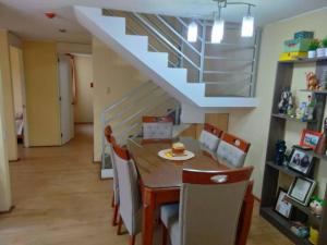 a dining room with a table and chairs and a staircase at Tait's House - Cómodo departamento Dúplex - Ate in Lima