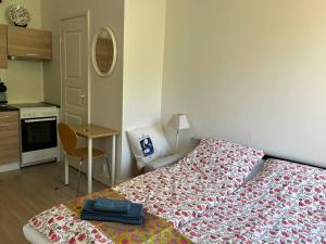 a bedroom with a bed and a table and a kitchen at Cozy apartment next to Finnish culture spots in Helsinki