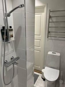 uma casa de banho com um chuveiro e um WC. em Cozy apartment next to Finnish culture spots em Helsinque