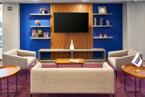 sala de estar con TV y pared azul en City Express by Marriott Toluca en Toluca