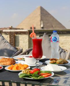 un tavolo ricoperto di piatti di cibo e di una bevanda di Master Pyramids Inn a Il Cairo