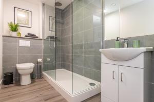 a bathroom with a shower and a sink and a toilet at Modern Spacious Apartment in Leicester City Centre with Free Parking! in Leicester