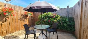 un tavolo e sedie con ombrellone su un patio di Havre de Paix - Maisonnette Charmante avec Extérieur Privé a Blois