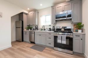 a kitchen with stainless steel appliances and white cabinets at Beautiful Apartment in Atwater Village in Glendale