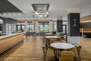 un restaurante con mesas, sillas y ventanas en Courtyard by Marriott Pocatello, en Pocatello