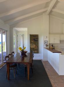 a kitchen and dining room with a wooden table and chairs at Ocean Beach in Tuki Tuki