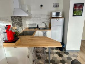 kuchnia z drewnianym stołem i białą lodówką w obiekcie LeCathedrale : F2 au cœur de Metz ! w Metz