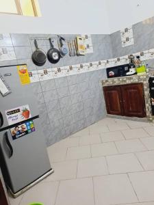 eine Küche mit einem Kühlschrank und Fliesenboden in der Unterkunft Cotonou dwelling AAC 1 in Porto-Novo