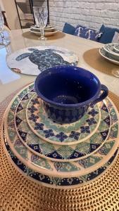 a blue bowl sitting on a plate on a table at Jardim das Palmeiras II Home Resort in Ubatuba