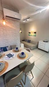 Jardim das Palmeiras II Home Resort في أوباتوبا: مطبخ وغرفة معيشة مع طاولة وكراسي