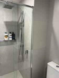 a shower with a glass door in a bathroom at Lovely City 1BR Apt Free Parking & Facing Mall in Canberra