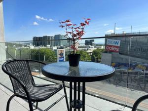 a table with a potted plant on top of a balcony at Lovely City 1BR Apt Free Parking & Facing Mall in Canberra