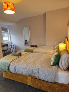 een slaapkamer met twee bedden en een spiegel bij SwankyHome4Groups/Contractors/M6 in Birmingham