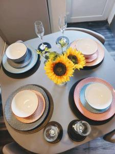 een tafel met borden, glazen en zonnebloemen erop bij SwankyHome4Groups/Contractors/M6 in Birmingham