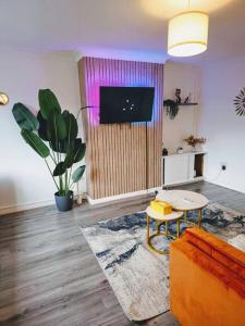 een woonkamer met een bank en een tv bij SwankyHome4Groups/Contractors/M6 in Birmingham