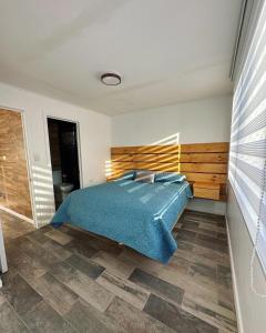 a bedroom with a bed with a wooden headboard at Complejo bosque escondido in Quillón