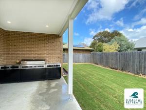 a kitchen in a backyard with a lawn at Scotty’s Place – Luxury Retreat in Inverloch