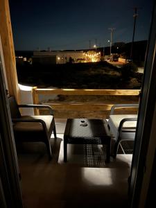 2 Stühle und ein Tisch auf dem Balkon in der Nacht in der Unterkunft Alexandra’s studios in Iraklia