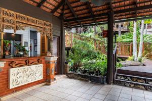 an outdoor patio with a bed and plants at Hibiscus Resort & Spa - Official Onsite Reception & Check In in Port Douglas +13 photos