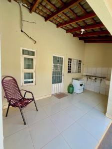 an empty room with a chair and a stove at Kitnet Realeza in Várzea Grande