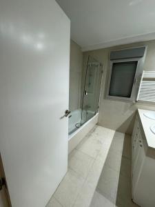 a white bathroom with a shower and a sink at Hotelly Recuero in Madrid