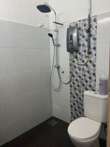 y baño con ducha, aseo y cabezal de ducha. en Nilai Bronizam Homestay, en Nilai