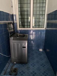 uma casa de banho com um lavatório e piso em azulejo azul em Nilai Bronizam Homestay em Nilai
