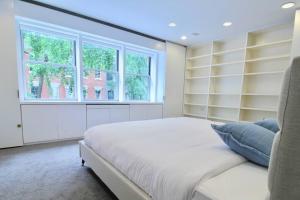 a bedroom with a large white bed and a window at Private Beautiful Eastside Townhome near UN in New York