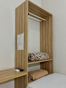 a wooden shelf with a bed in a room at Kitnet Realeza in Várzea Grande